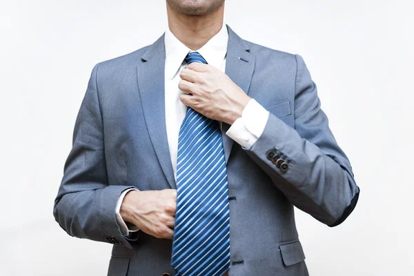 Молодой бизнесмен настраивает галстук — стоковое фото
