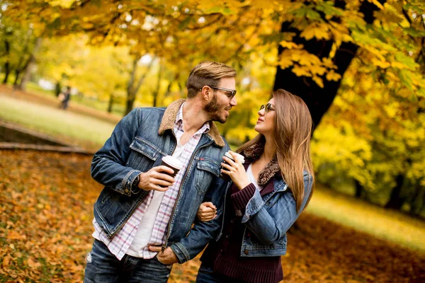 Jovem casal no parque de outono com café — Fotografia de Stock