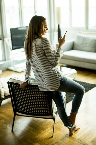 Young woman with phone in the room — Stock Photo, Image