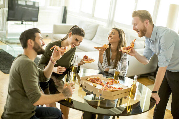 Friends eating pizza in the modern interior