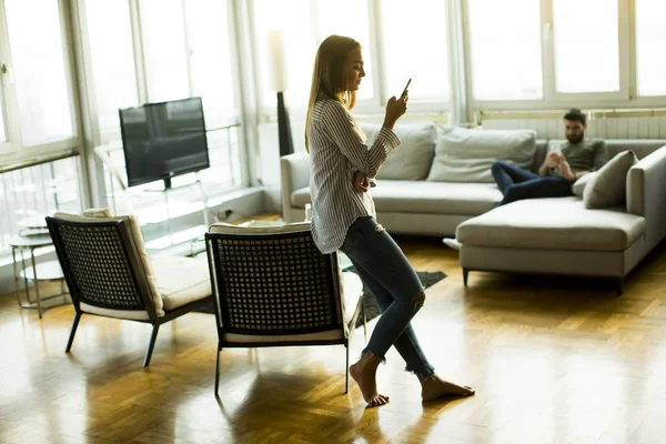 Mujer joven con teléfono en la habitación —  Fotos de Stock