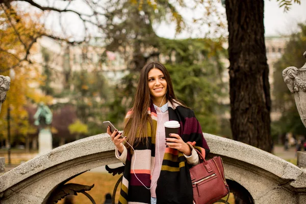 Mujer con teléfono y café al aire libre —  Fotos de Stock