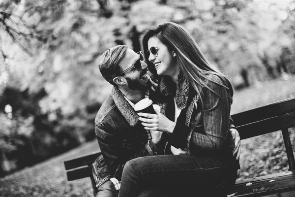 Jovem casal no parque de outono com café — Fotografia de Stock