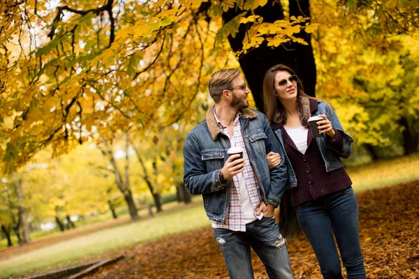Jeune couple dans le parc d'automne avec café — Photo