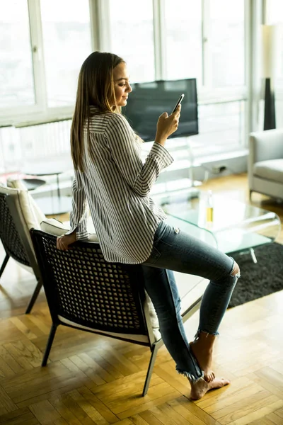 Giovane donna con telefono in camera — Foto Stock