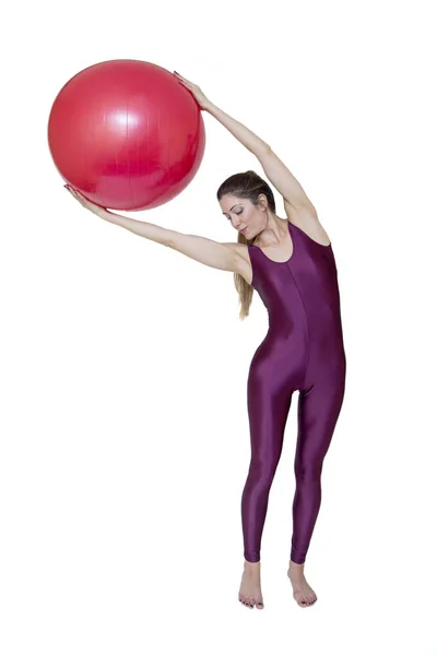 Vrouw met rode pilates bal oefeningen Stockfoto