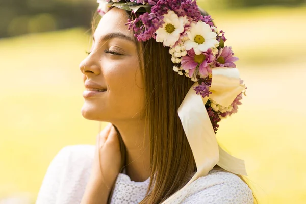 Mujer joven con corona de flores —  Fotos de Stock