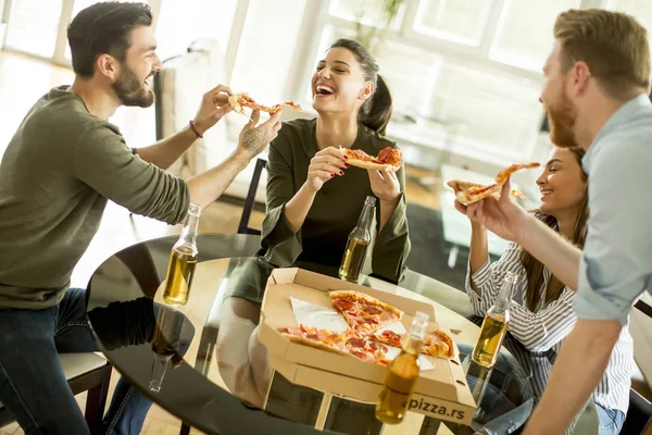 Friends eating pizza in the modern interior — Stock Photo, Image