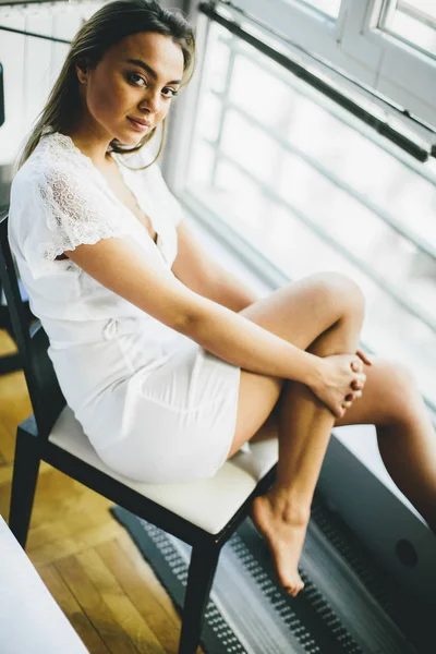 Mujer joven en el dormitorio — Foto de Stock