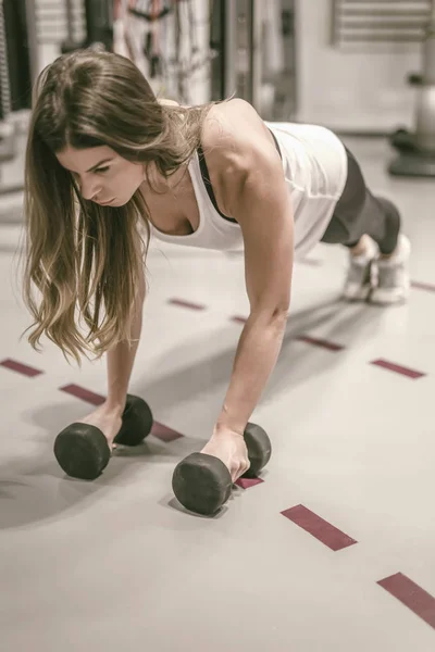 Spor salonunda çalışan genç bir kadın. — Stok fotoğraf