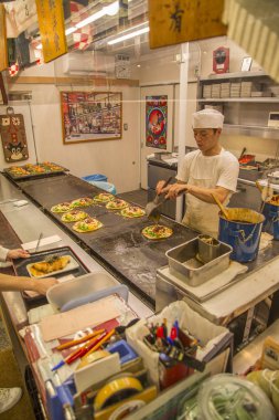 Kimliği belirsiz adam Okonomiyaki hazırlanıyor 
