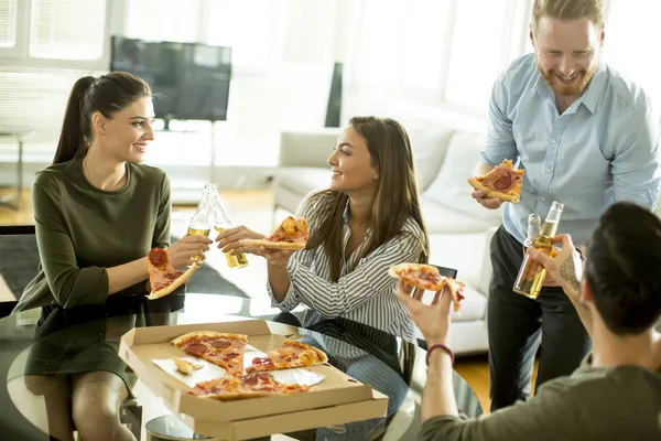 Freunde essen Pizza im modernen Interieur — Stockfoto