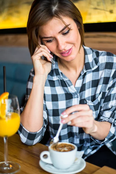 Kobieta za pomocą telefonów komórkowych w kawiarni — Zdjęcie stockowe