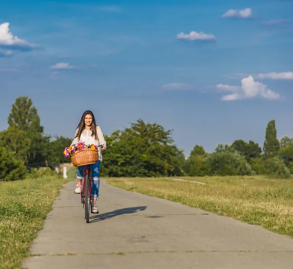 Junge lächelnde Frau fährt Fahrrad — Stockfoto