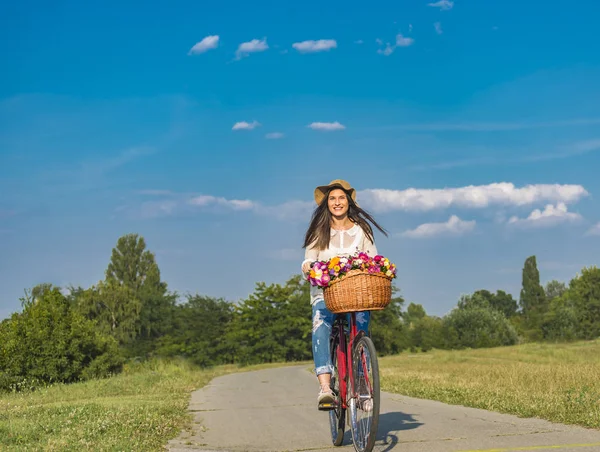Jovem mulher sorridente monta uma bicicleta — Fotografia de Stock