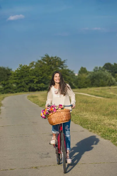 Jonge lachende vrouw rijdt een fiets — Stockfoto