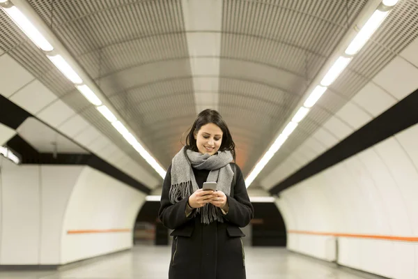 Wanita muda berdiri di stasiun kereta bawah tanah — Stok Foto
