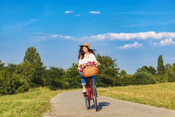 Young smiling woman rides a bicycle — Stock Photo, Image