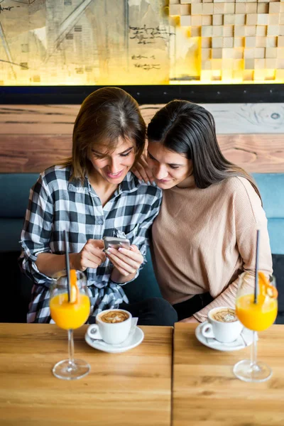 Dwóch młodych kobiet przyjaciół siedząc w kawiarni, picia kawy i ju — Zdjęcie stockowe