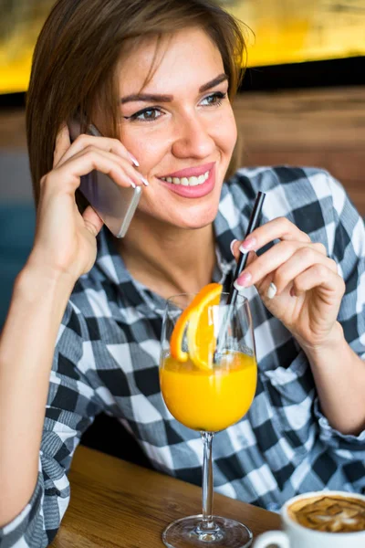 Kobieta za pomocą telefonów komórkowych w kawiarni — Zdjęcie stockowe