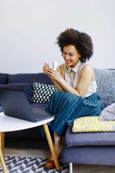 Ung Kvinna Med Lockigt Hår Använder Laptop Och Sitter Soffan — Stockfoto