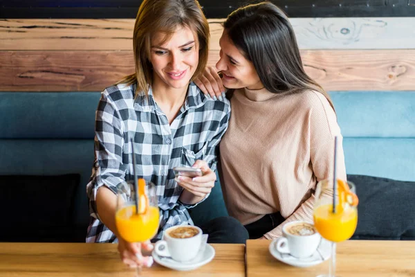 Dwóch Młodych Kobiet Przyjaciół Siedząc Kawiarni Picia Kawy Soku Oglądać — Zdjęcie stockowe