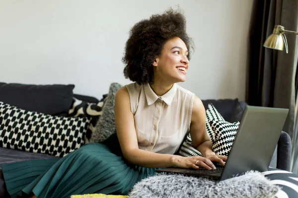 Jonge Vrouw Met Krullend Haar Gebruik Laptop Zittend Bank Thuis — Stockfoto