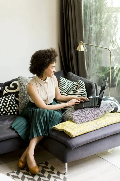 Jonge Vrouw Met Krullend Haar Gebruik Laptop Zittend Bank Thuis — Stockfoto