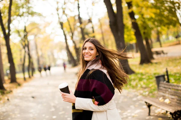 Mujer joven con café en el parque de otoño — Foto de Stock