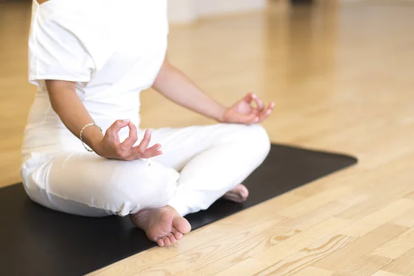 Jonge vrouw cross benen zittend op de vloer doen yoga — Stockfoto