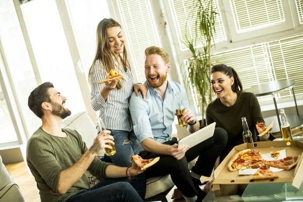 Amigos comendo pizza no interior moderno — Fotografia de Stock