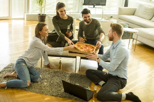 Amigos comendo pizza no interior moderno — Fotografia de Stock