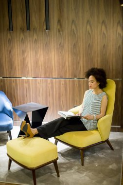 Genç kadın sittinh sarı bir iskemle