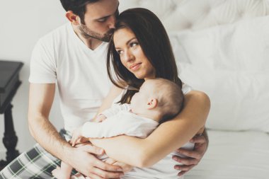 Yeni doğmuş bebeğiyle mutlu bir aile 