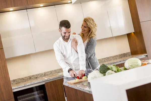 Jovem ajudando sua namorada cozinhar — Fotografia de Stock