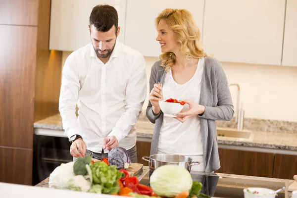 Hombre ayudando a su novia a cocinar en la cocina moderna — Foto de Stock