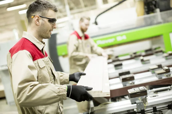 Trabajadores jóvenes en una fábrica — Foto de Stock