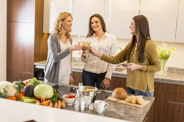 Três jovens mulheres na cozinha moderna — Fotografia de Stock