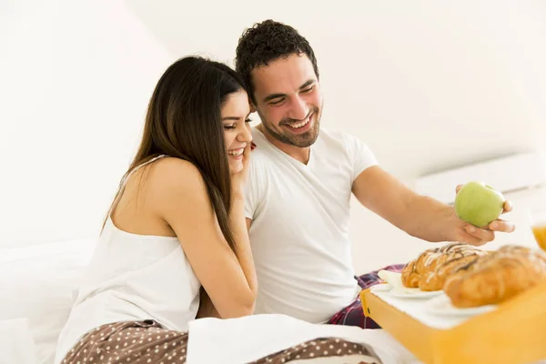 Paar ontbijten in hun bed thuis — Stockfoto