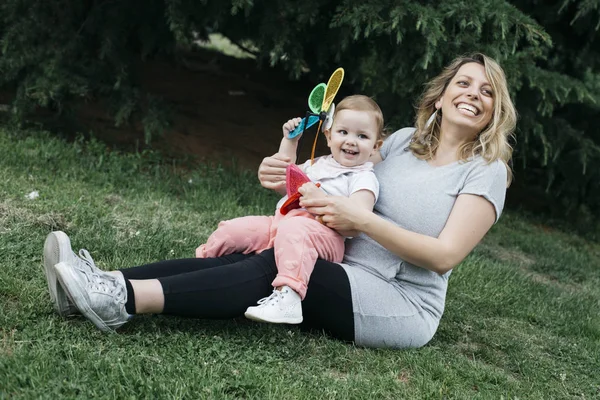Hamile anne ve küçük kızı çimlerin üzerine — Stok fotoğraf