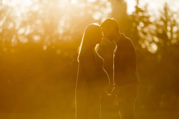 Kobieta w ciąży i jej kochający mężczyzna pozowanie na jesień park — Zdjęcie stockowe