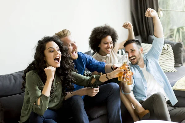 Vänner titta på Tv, dricka cider och ha roligt i rummet — Stockfoto