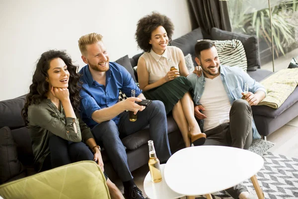 Amigos assistindo TV, bebendo cidra e se divertindo no quarto — Fotografia de Stock