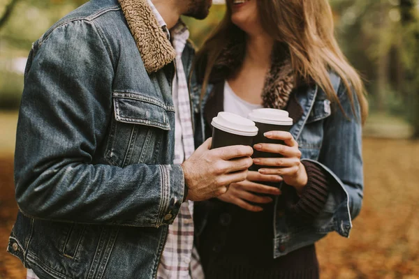 Coppia romantica con caffè passeggiando all'aperto nel parco autunnale — Foto Stock
