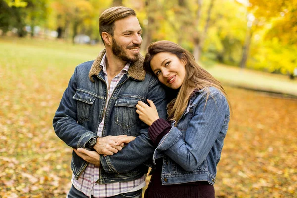 Casal sorridente abraçando no parque de outono — Fotografia de Stock