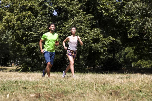 Jovem casal correndo no parque — Fotografia de Stock