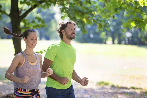 Pareja joven corriendo en el parque — Foto de Stock