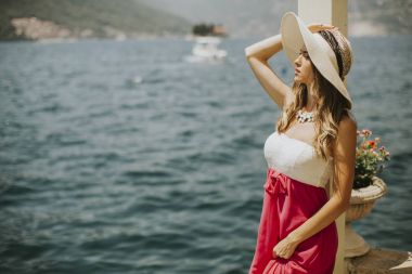 Denizin kenarında genç çekici kadın pozlar