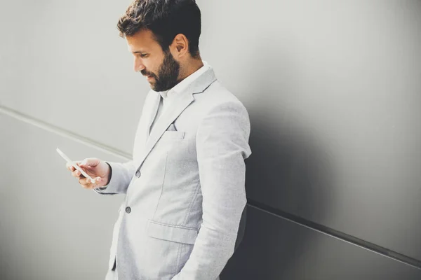 Giovane imprenditore che utilizza il telefono in ufficio — Foto Stock