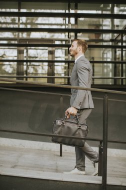 Yakışıklı adam ofis binası tarafından yürüyüş